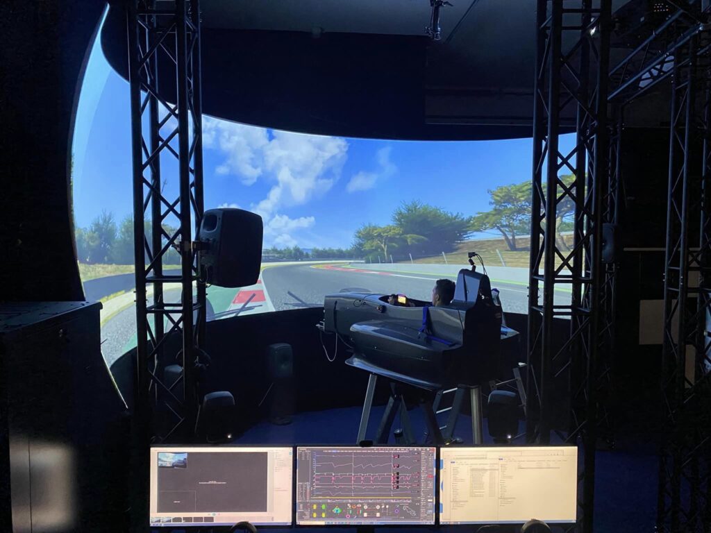 CFA's simulator environment with a large curved display and a driver in front of it.